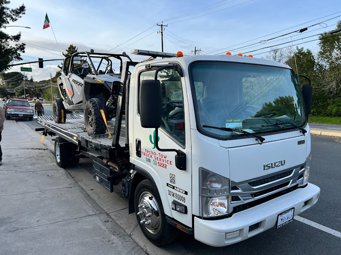 A tow truck with a boat on the back of it