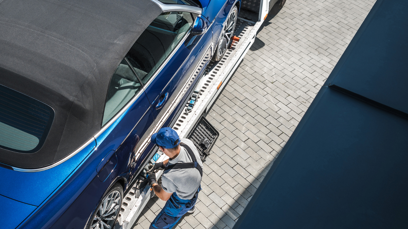 A man working on a car in a parking lot