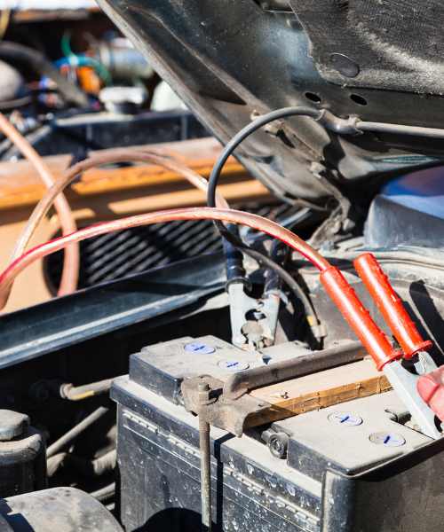 A person is working on a car battery